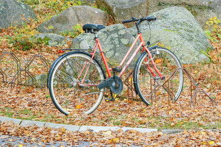 32967271-ronneby-sweden--october-26-2014-orange-greenfield-bicycle-standing-in-rack-in-autumn-lots-of-leaves-